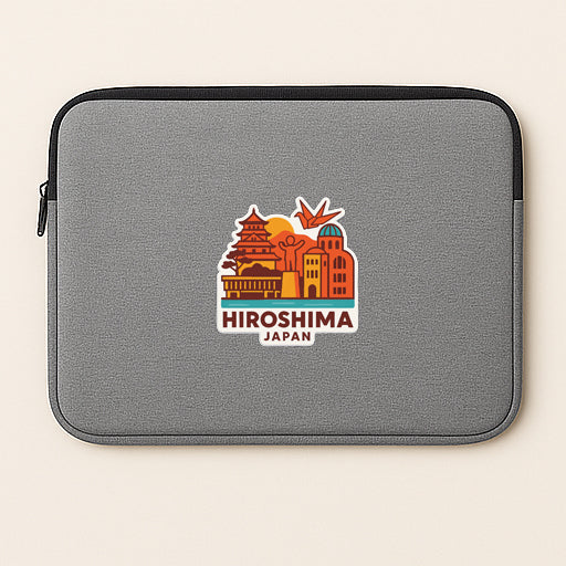A gray laptop sleeve with a colorful sticker depicting the skyline of Hiroshima, Japan.