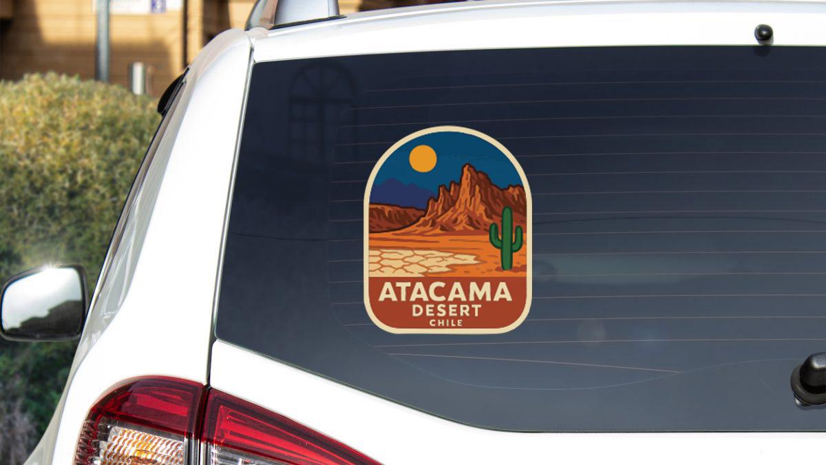 a sticker on the rear window of a white car that says "Atacama Desert Chile".