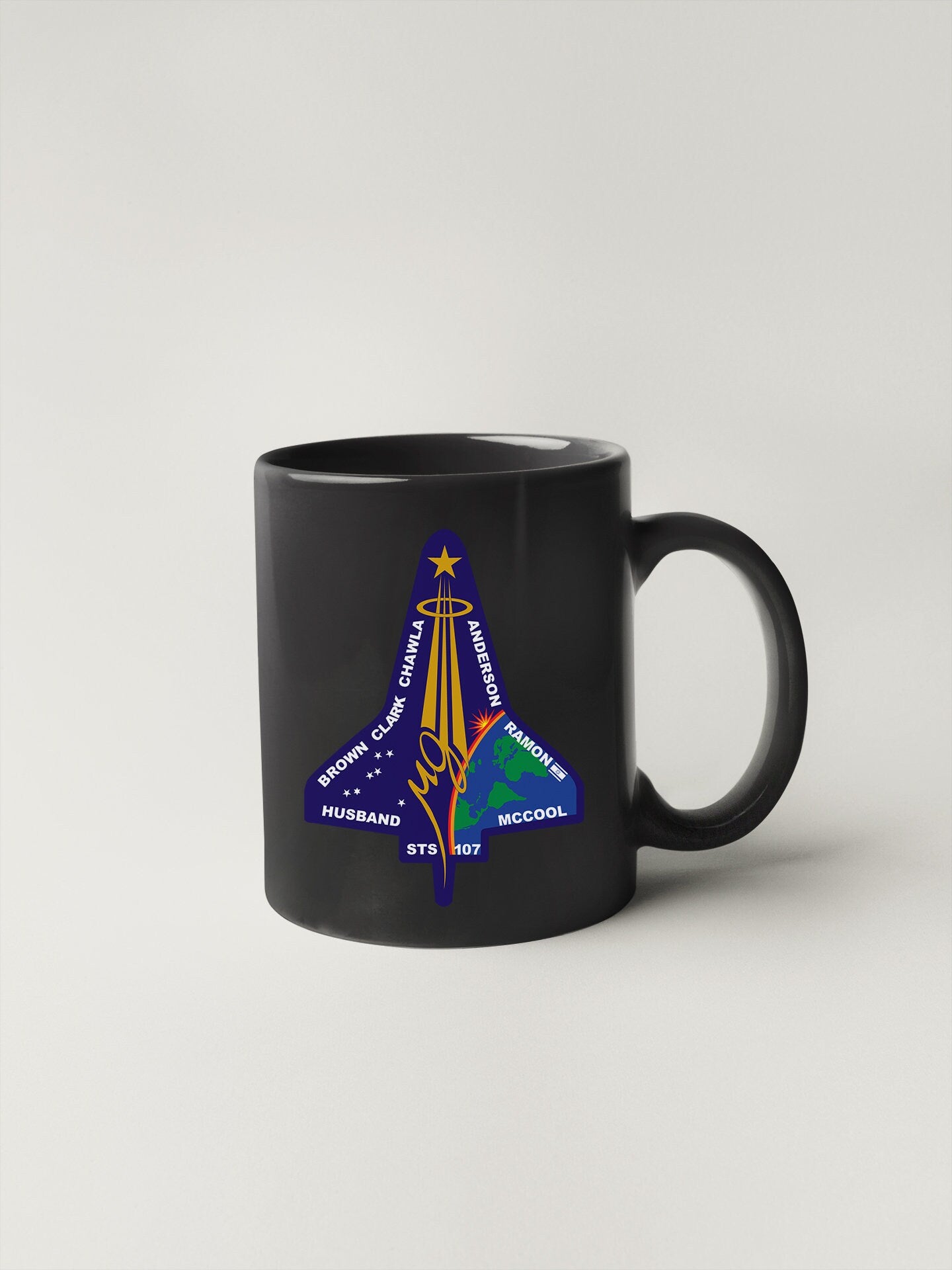 a black coffee mug with a space shuttle on it