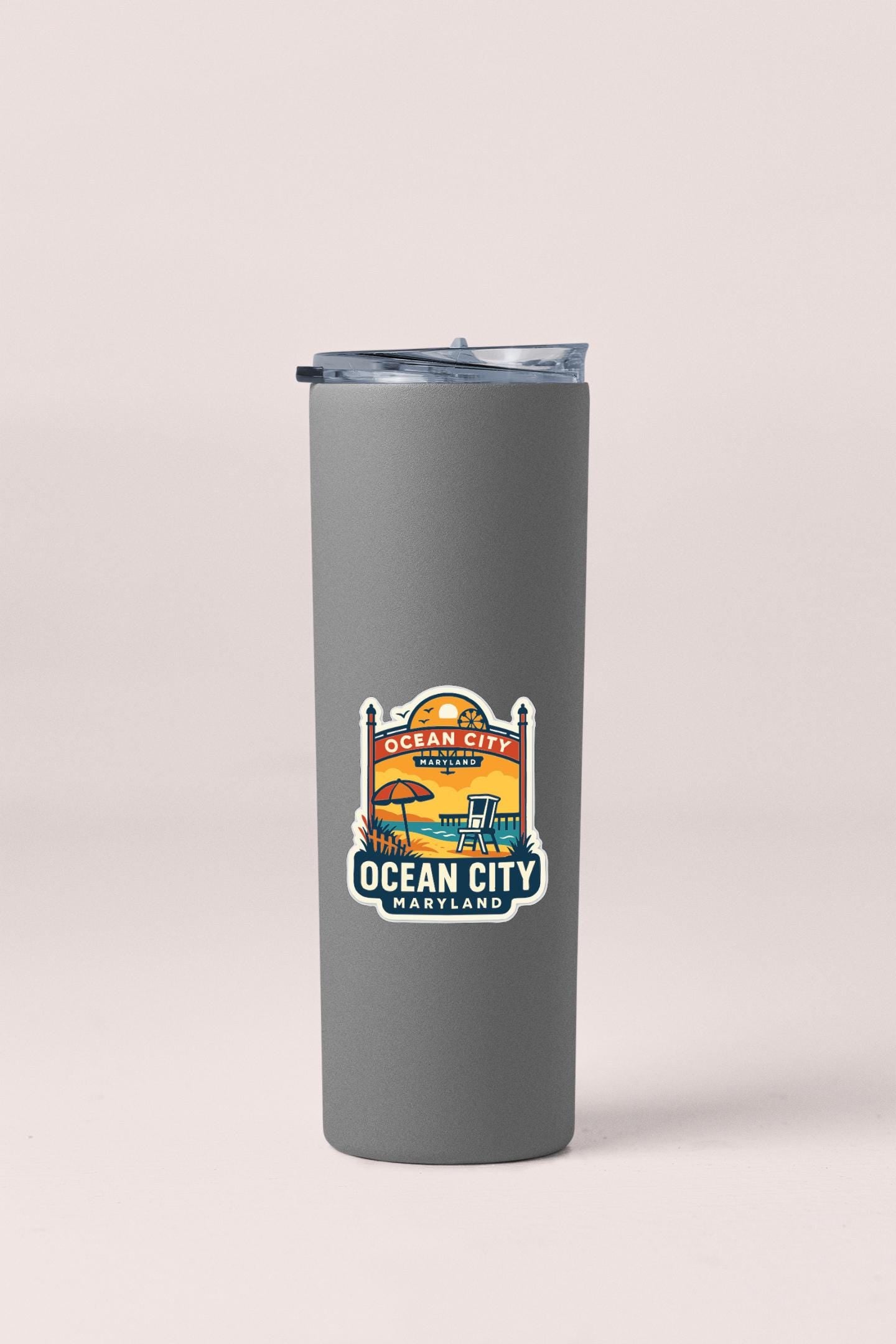 A gray insulated tumbler with a sticker depicting Ocean City, Maryland.