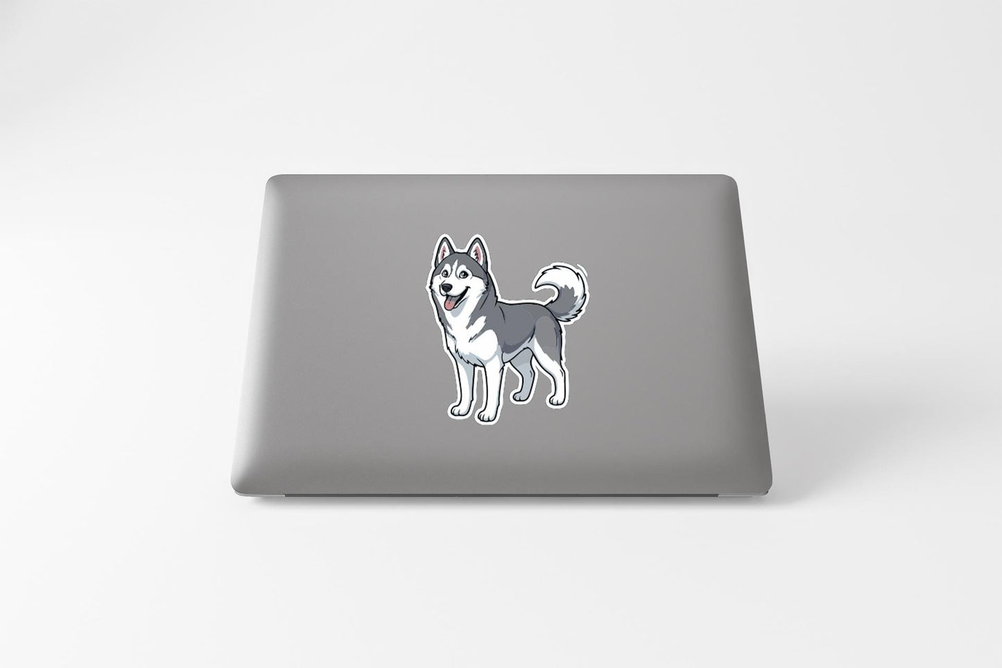 A sticker of a husky dog is on the back of a laptop.