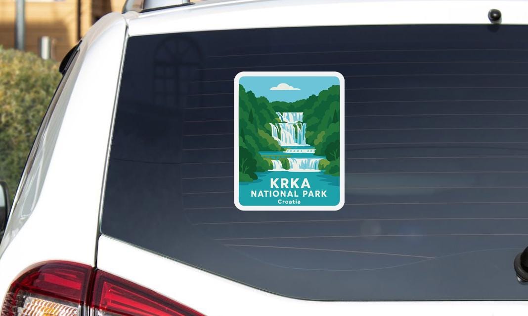A sticker on the rear window of a car, depicting a waterfall in a national park in Croatia.