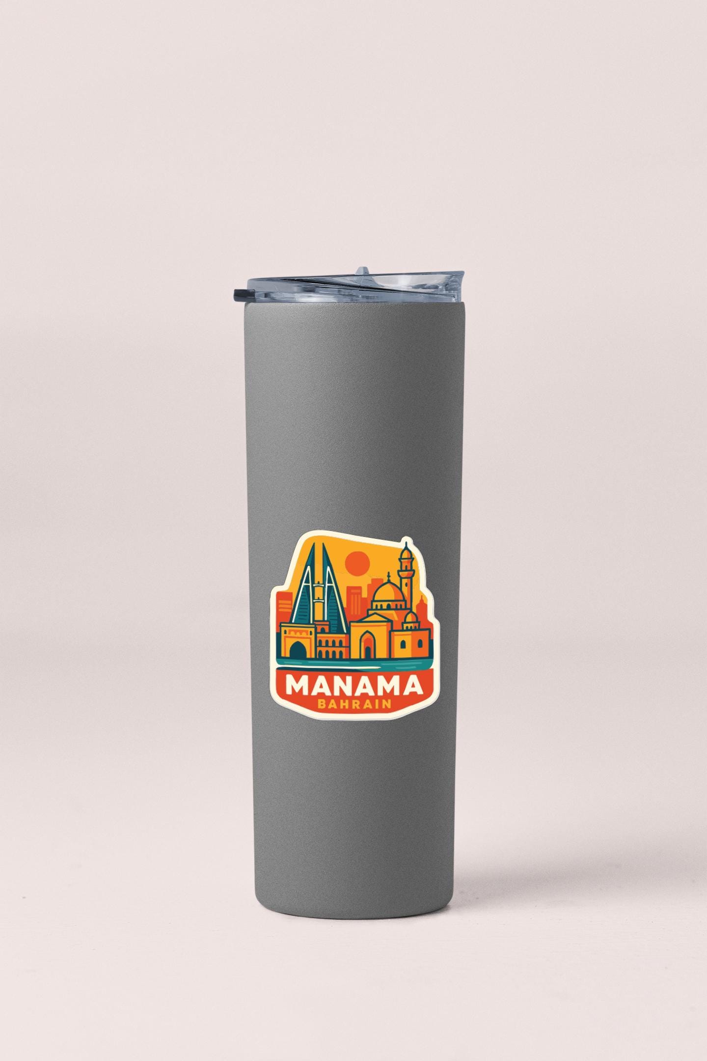 A gray insulated tumbler with a sticker depicting the city of Manama, Bahrain.