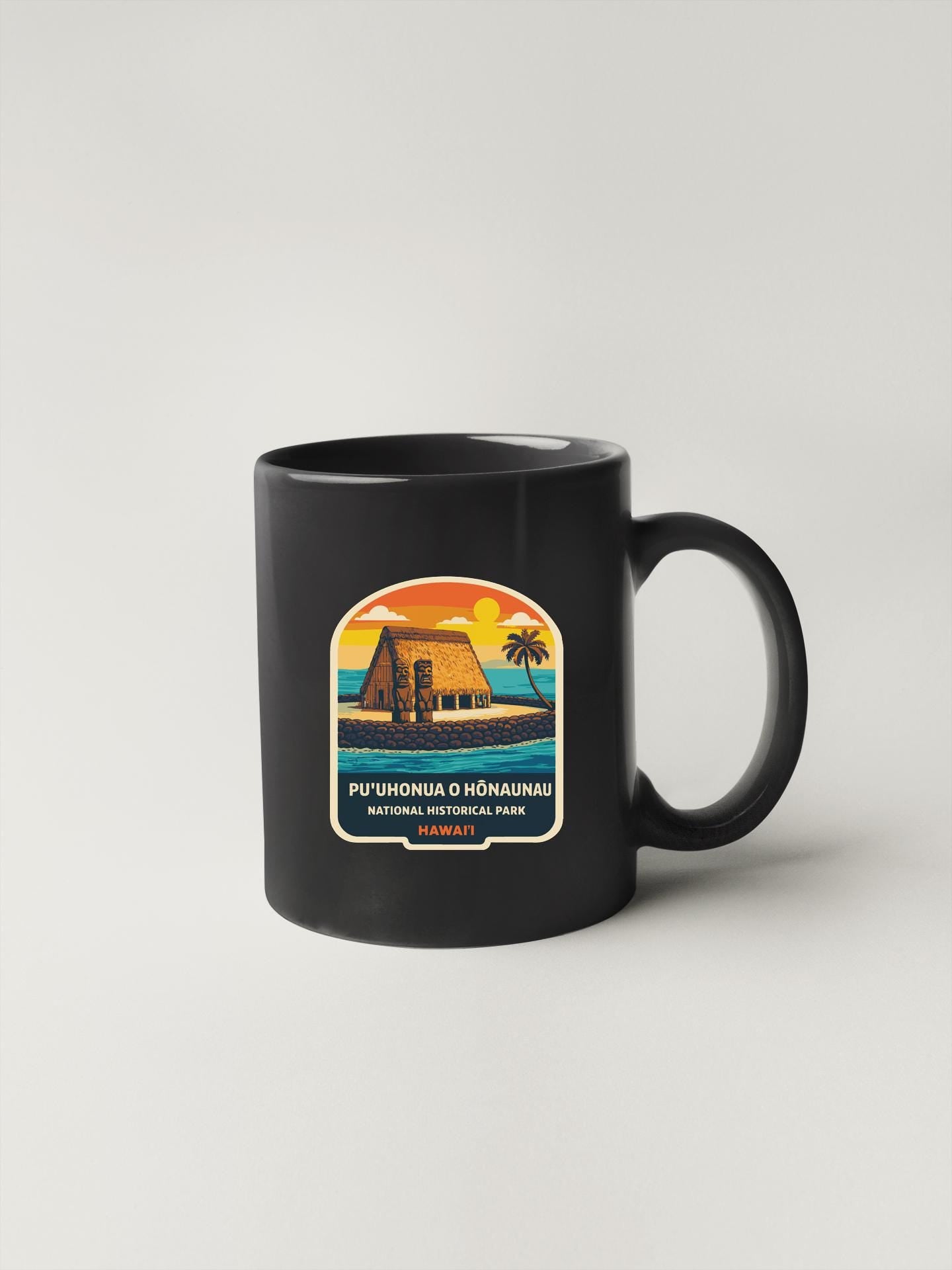 A black coffee mug with a colorful illustration of a tropical beach scene and the text "PUØHONUA O HONAHAU NATIONAL HISTORICAL PARK HONOHAU" printed on it.