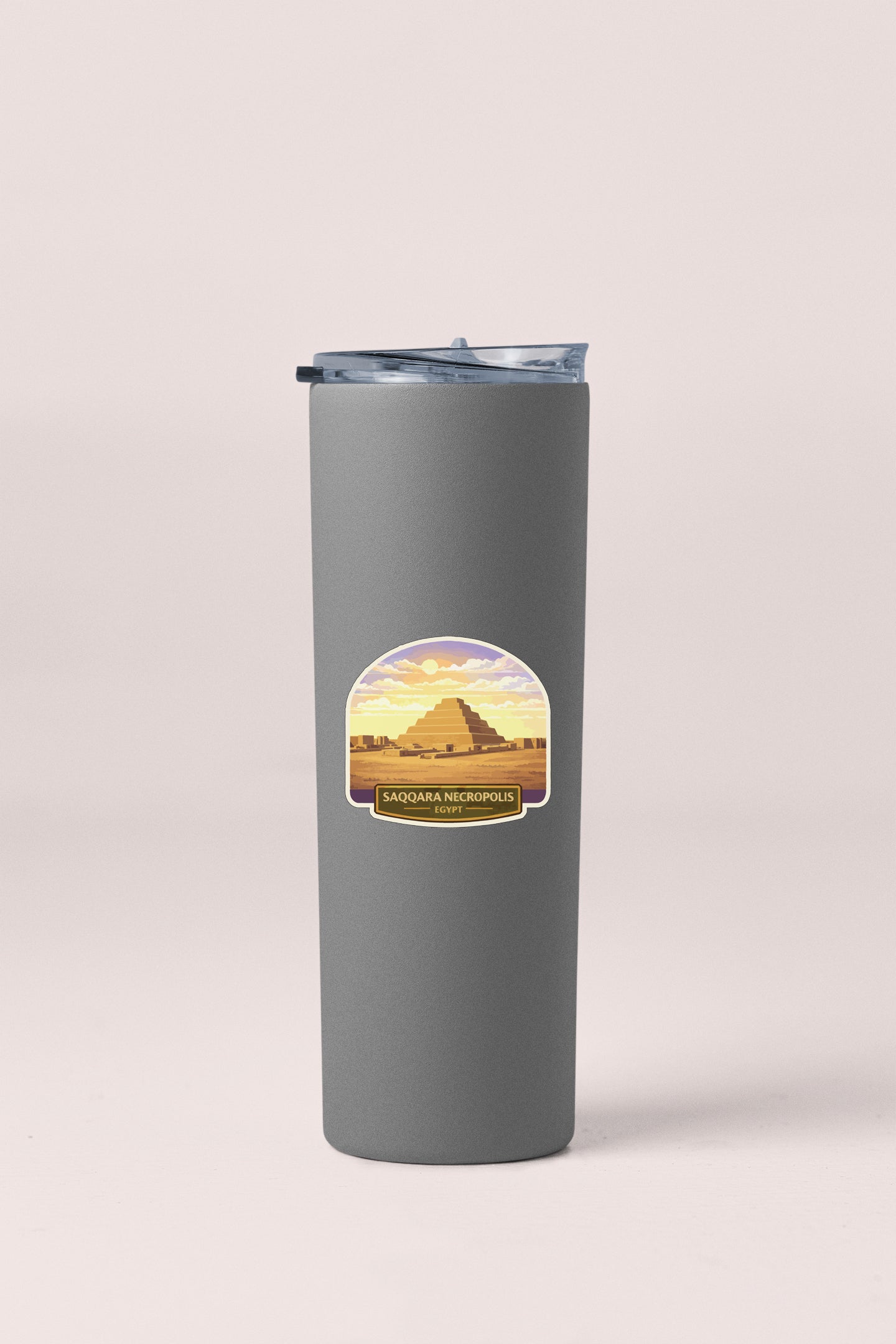 A gray cylindrical container with a lid and a label featuring an illustration of the Luxor pyramid.