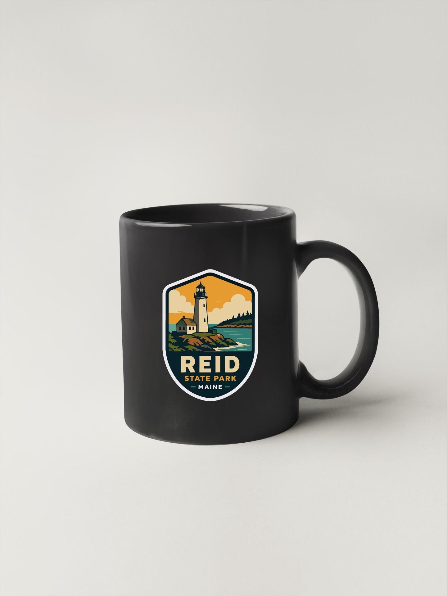 A black coffee mug with a shield-shaped logo featuring a lighthouse and a scenic landscape.