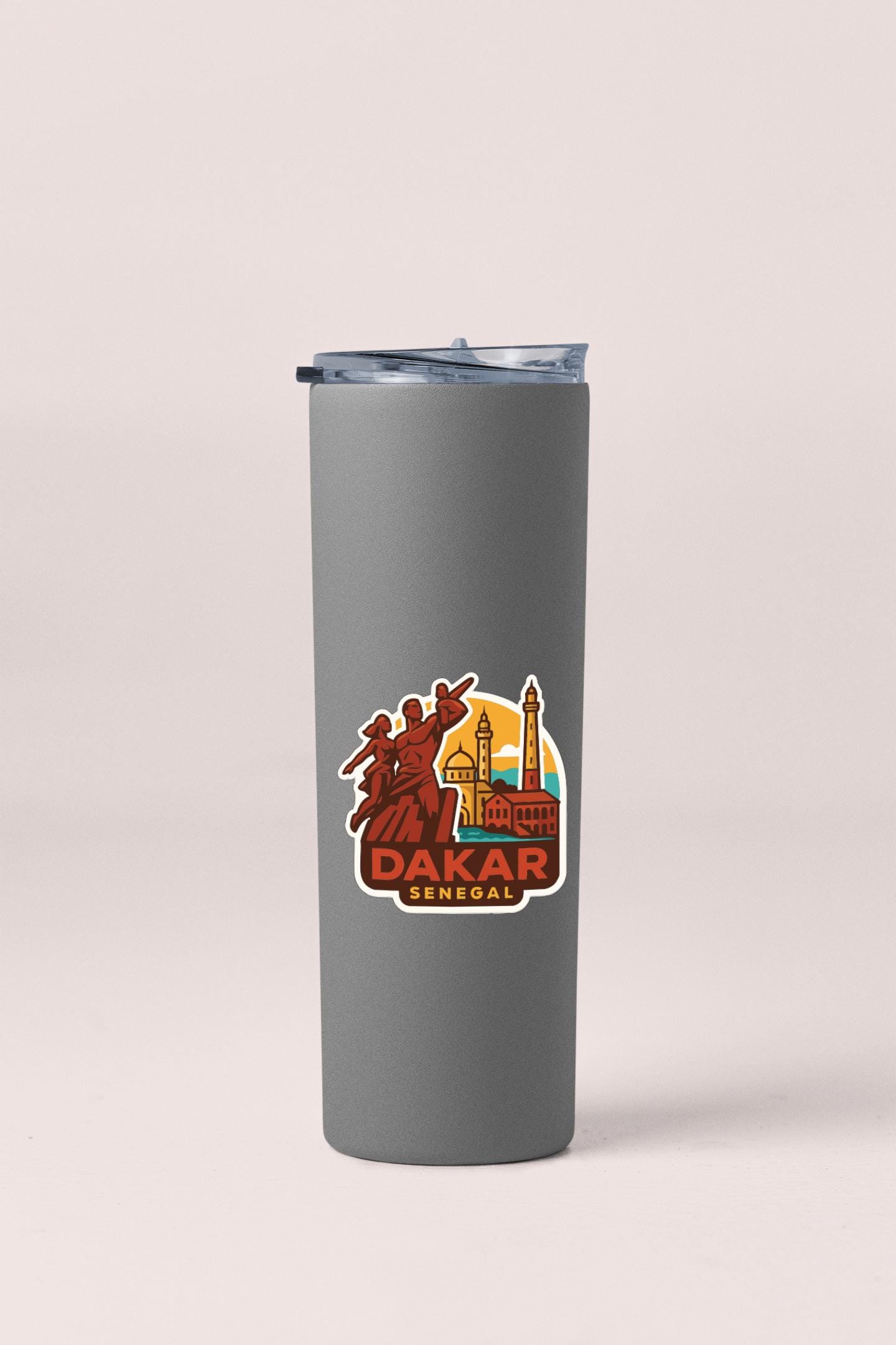 A gray insulated tumbler with a sticker depicting a city skyline and the text "DAKAR SENEGAL".