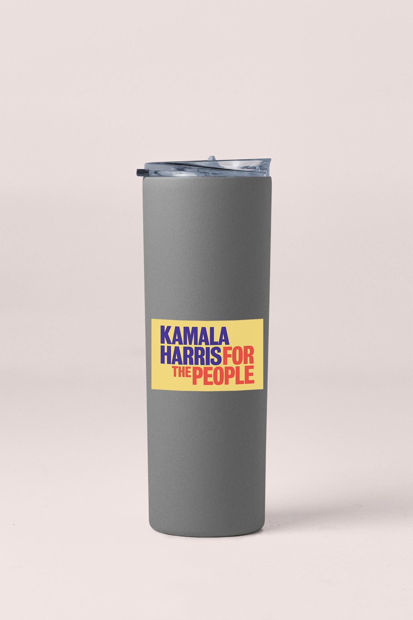 a gray tumbler with a yellow sticker on it