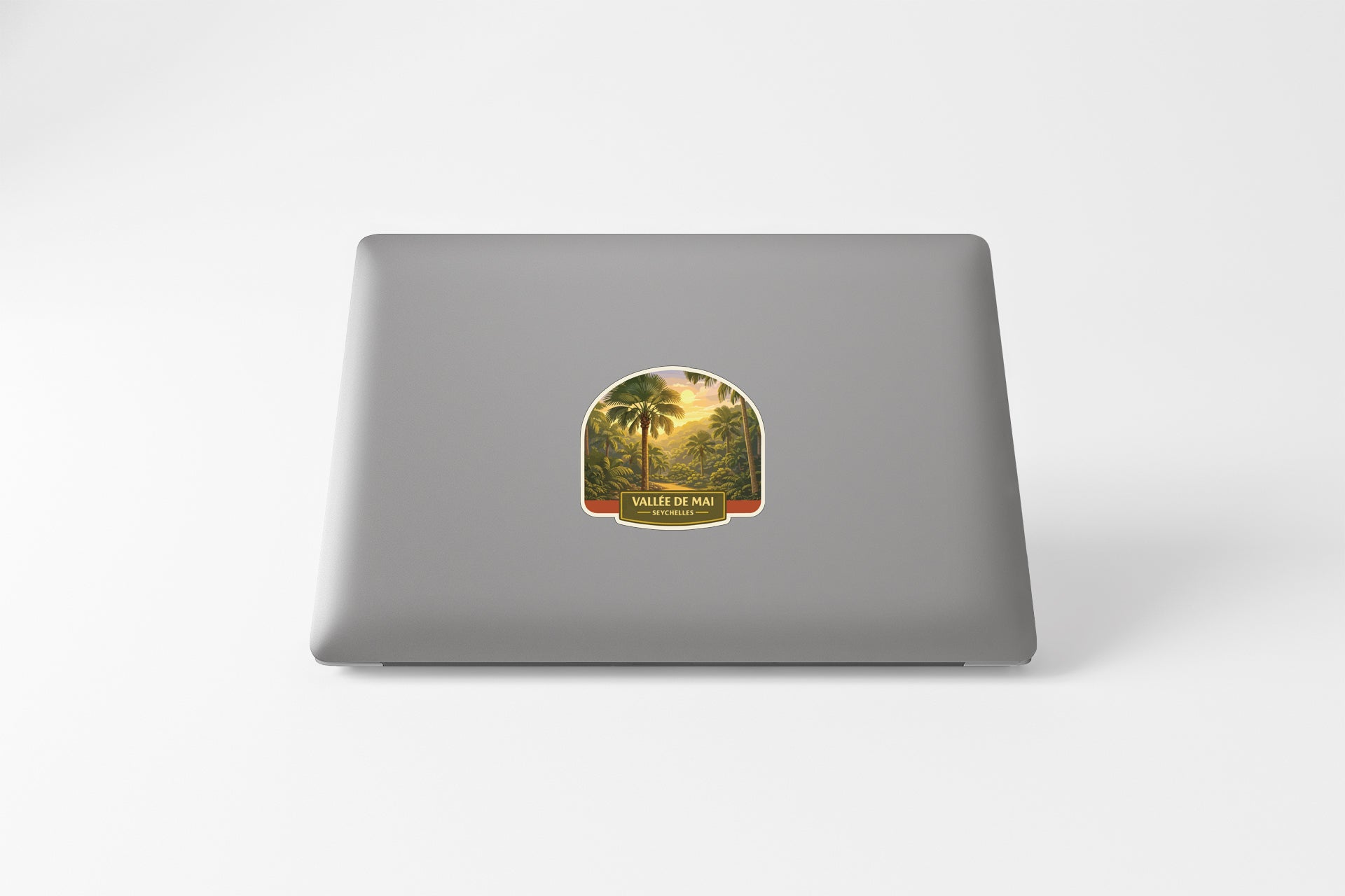 a sticker with a tropical landscape on the back of a laptop.