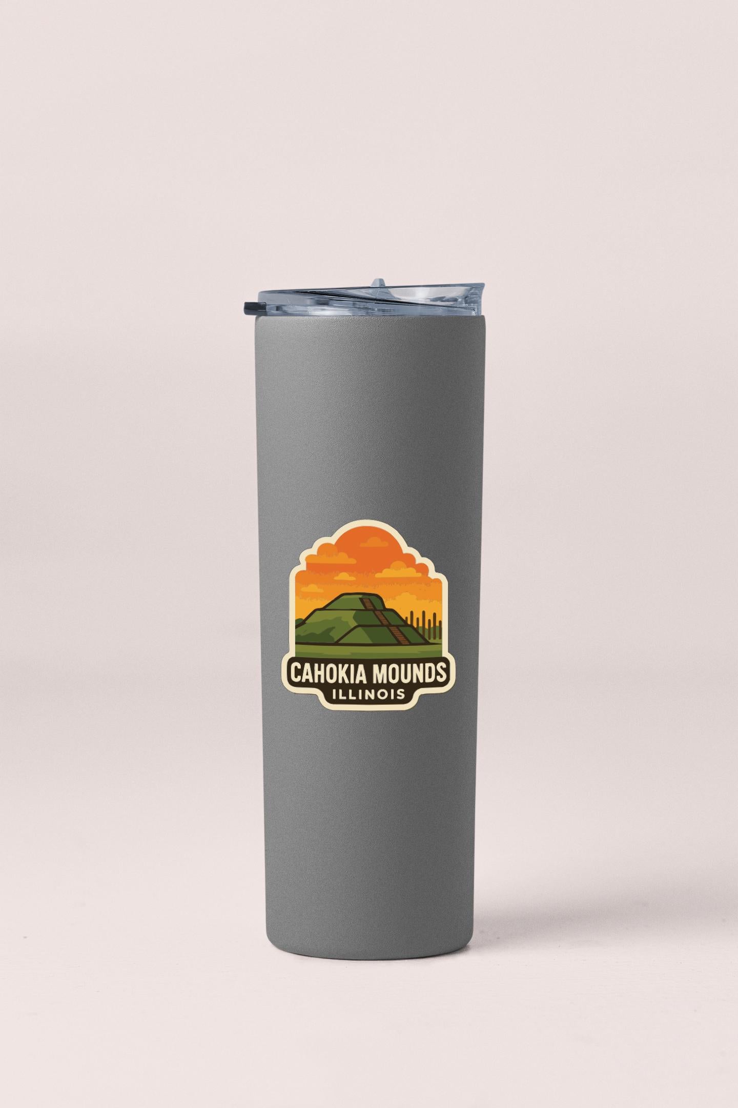 A gray insulated tumbler with a sticker depicting a mountain landscape and the text "CAHOKIA MOUNDS ILLINOIS".