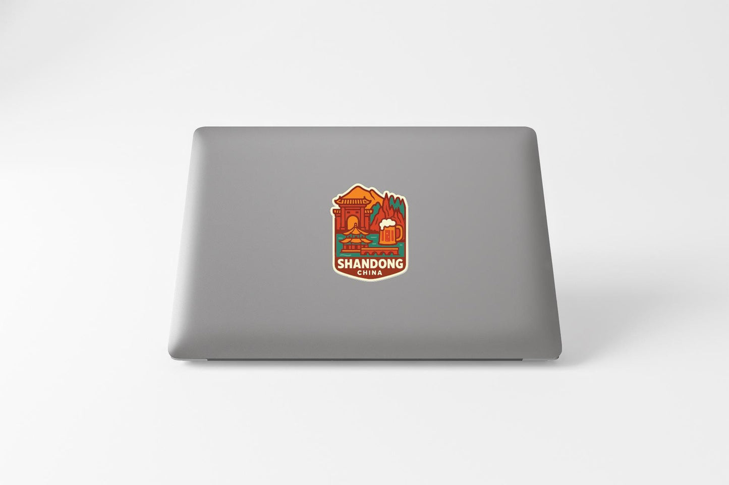 a sticker with an illustration of a building and a beer mug, along with the text "SHANDONG CHINA" printed on it.