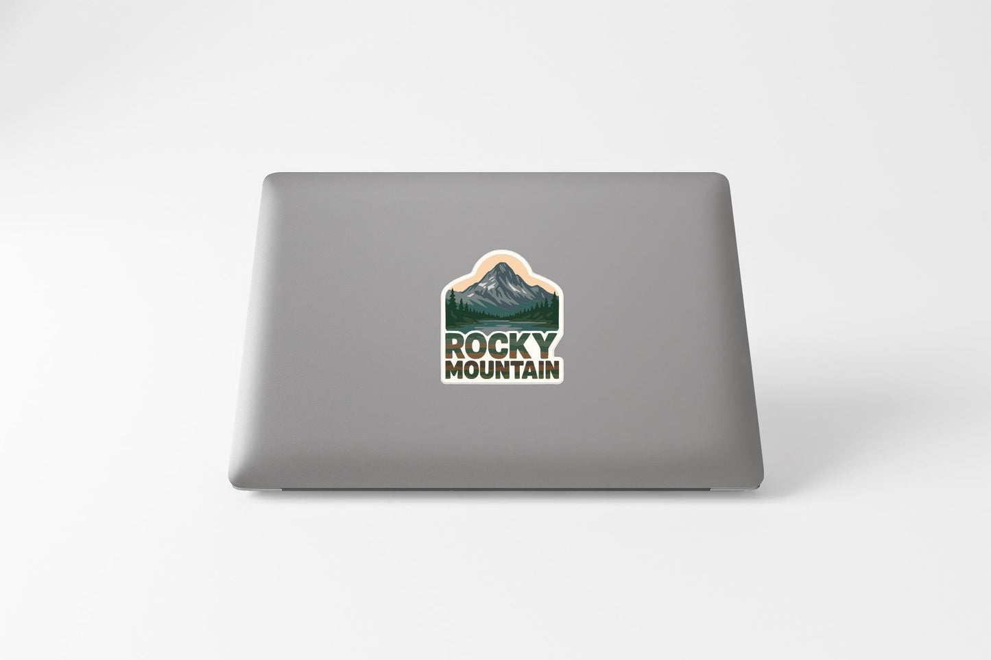 a laptop with a sticker on the back of it, featuring a mountain landscape.