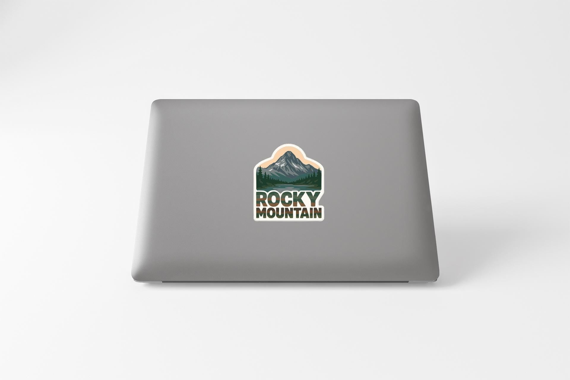 a laptop with a sticker on the back of it, featuring a mountain landscape.