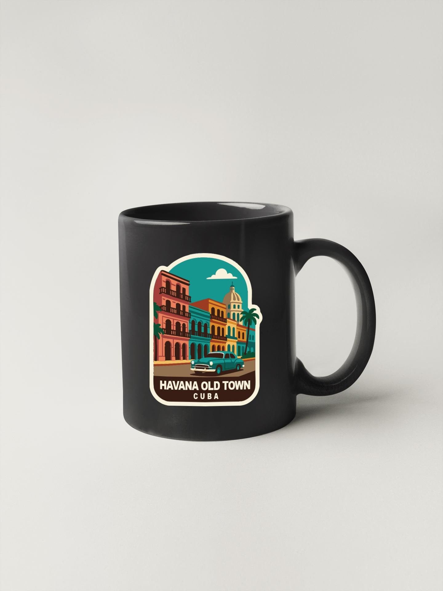 A black coffee mug with a colorful illustration of Havana, Cuba, featuring buildings, cars, and palm trees.