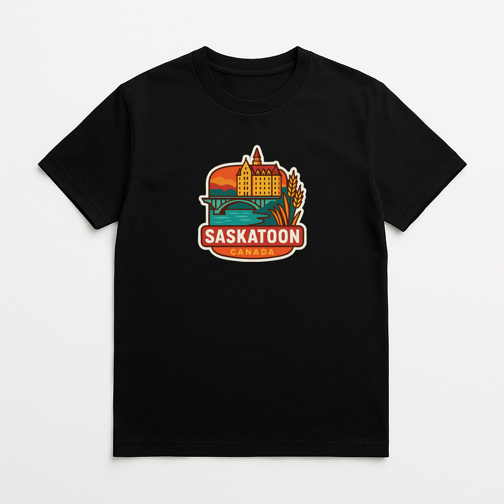 A black t-shirt with a graphic design depicting a cityscape and the text "Saskatoon, Canada" printed on it.