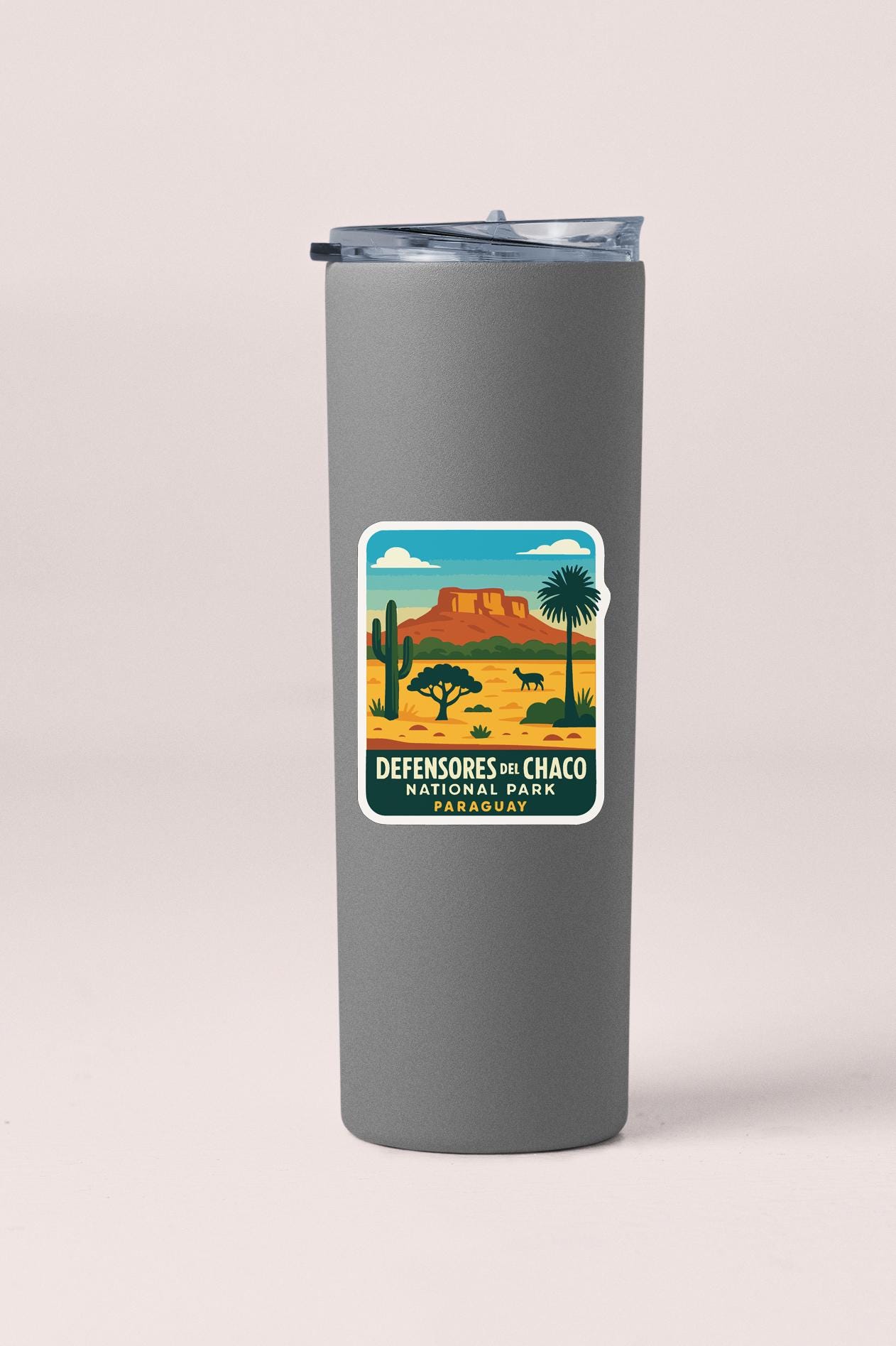 A gray insulated tumbler with a sticker depicting a desert landscape and a mountain in the background.