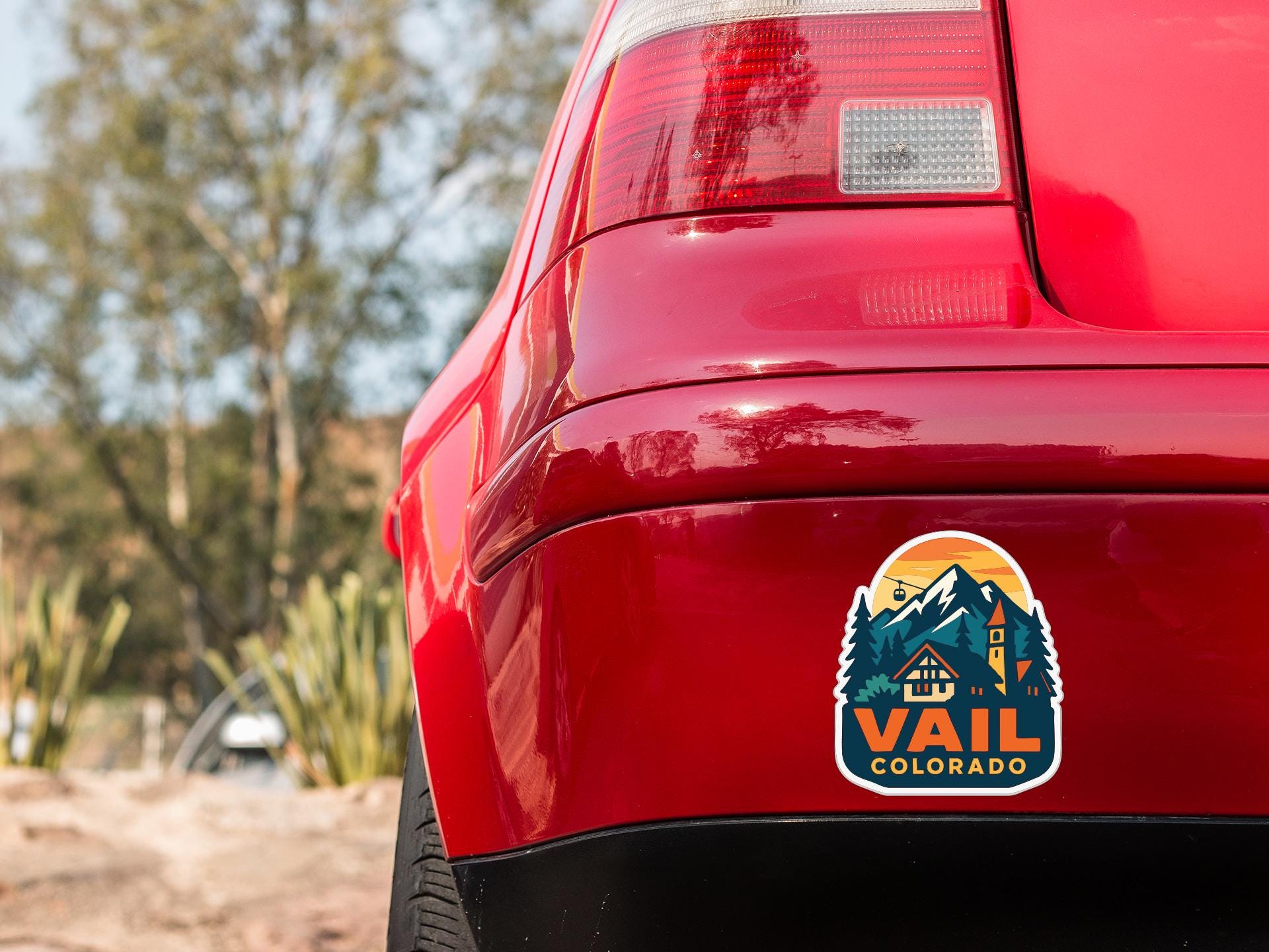 the rear end of a red car with a sticker on the trunk that says "Vail Colorado".