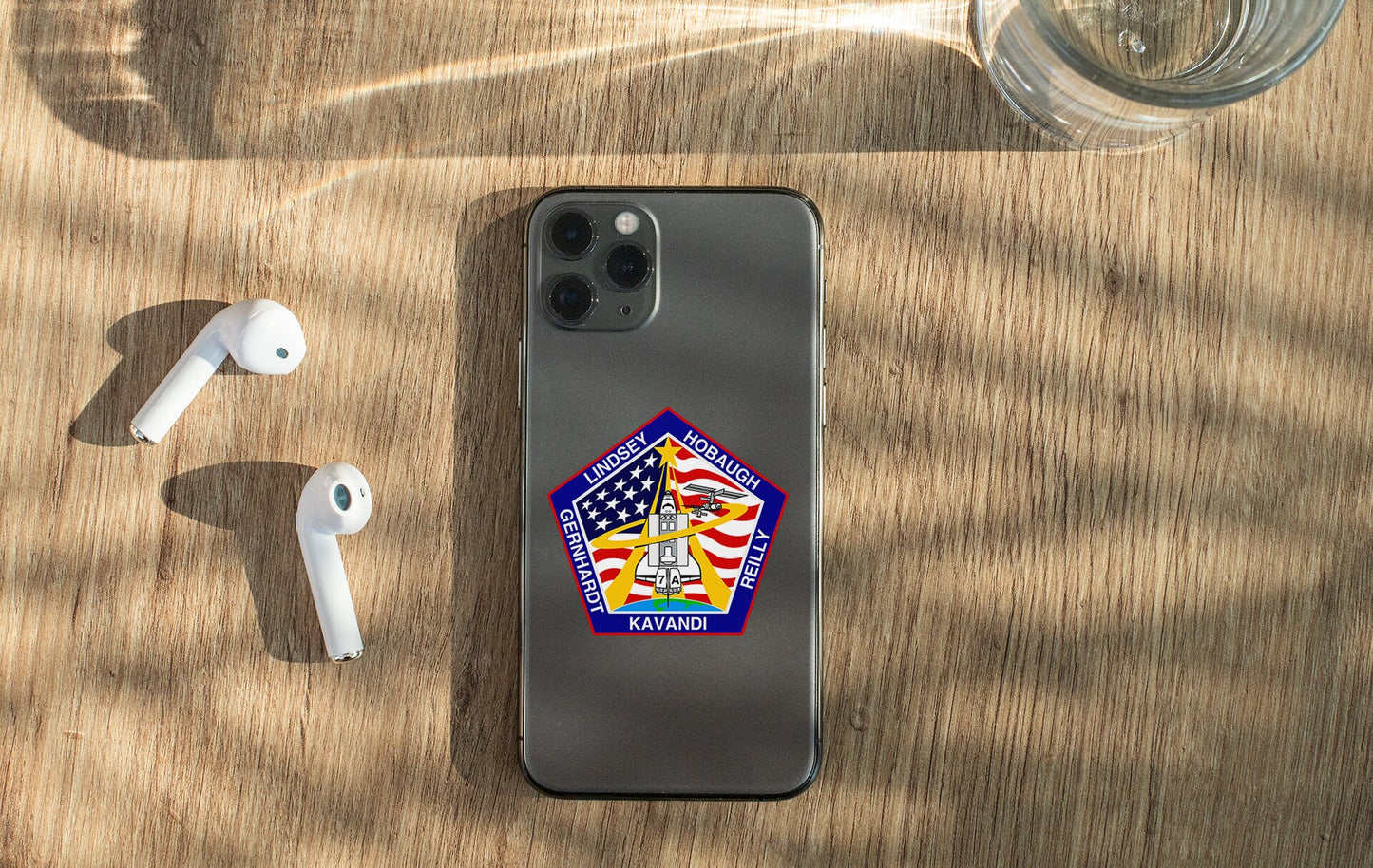 a phone with a sticker on it next to ear buds