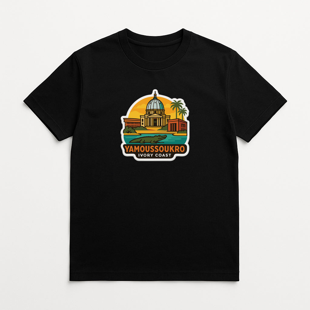 A black t-shirt with a graphic design depicting a building with a dome and palm trees, along with the text "YAMOUSOUKRO Ivory Coast" printed on it.