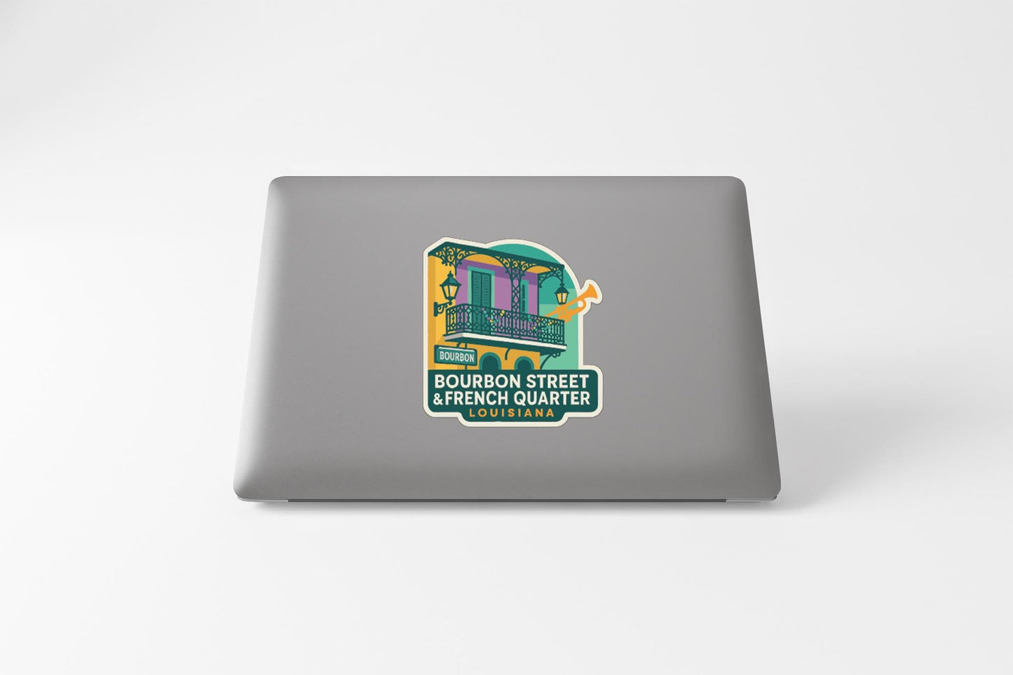 a sticker on a laptop with a colorful illustration of a building and text that reads "BOURBON STREET & FRENCH QUARTER BOUBAI".