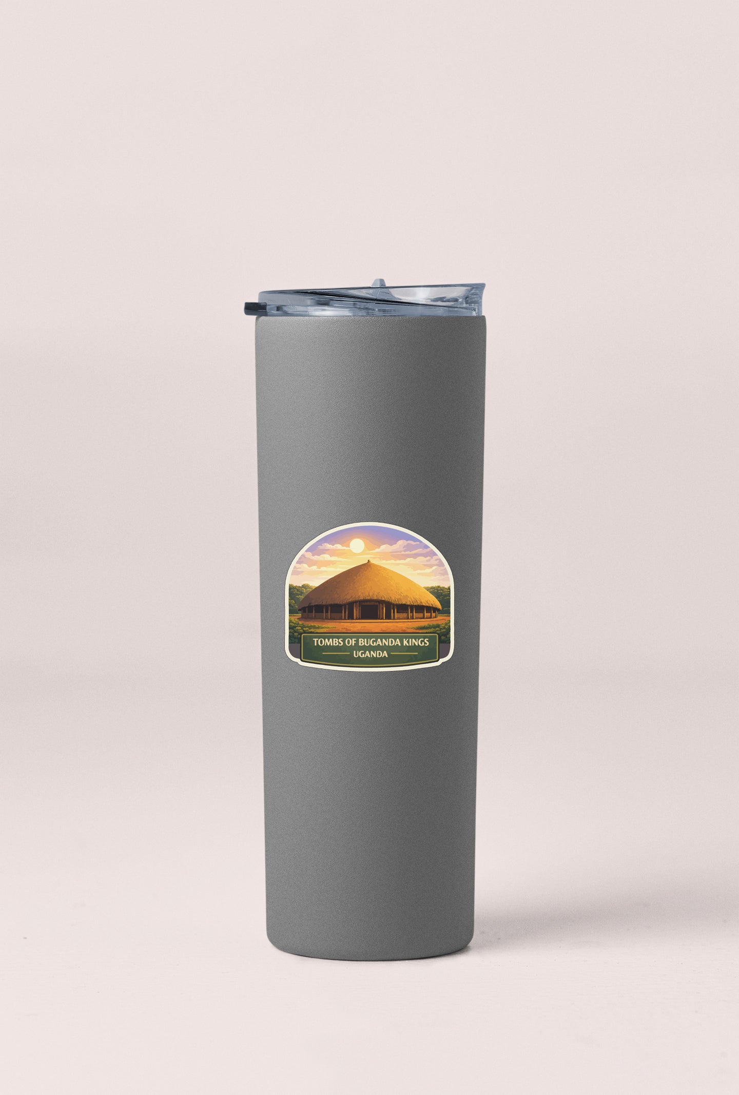 A gray insulated tumbler with a label that says "TOMBS OF BUGANDA KINGINGS BUGANDA" and "GANDIA" printed on it.
