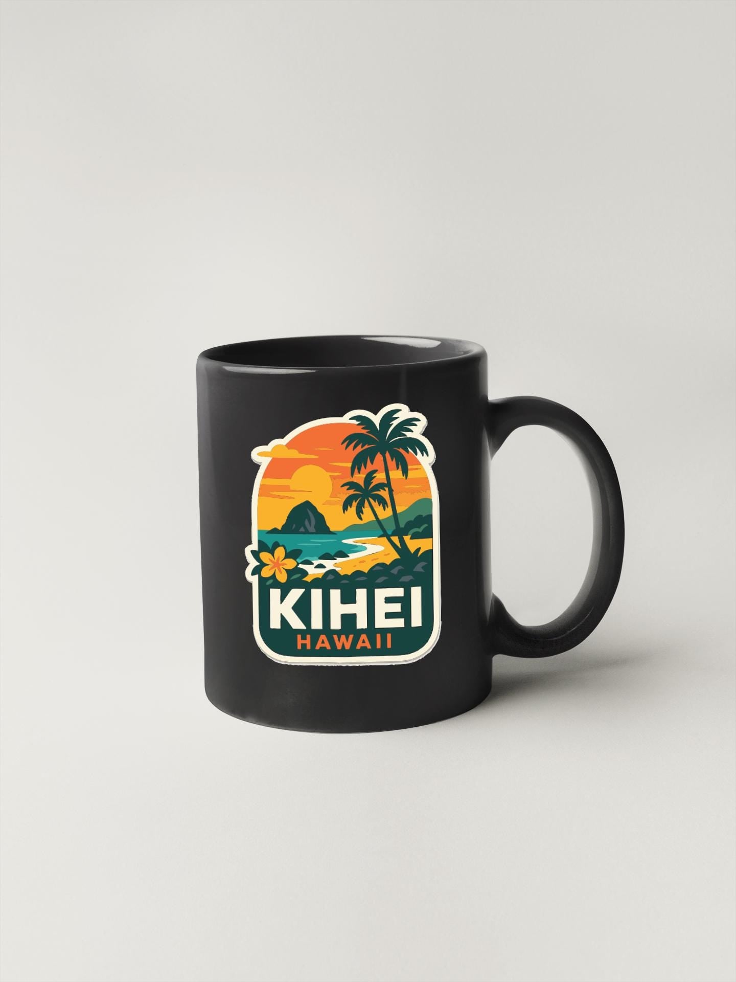 A black coffee mug with a tropical island and sunset design featuring the text "KIHEI HAWAII" printed on it.
