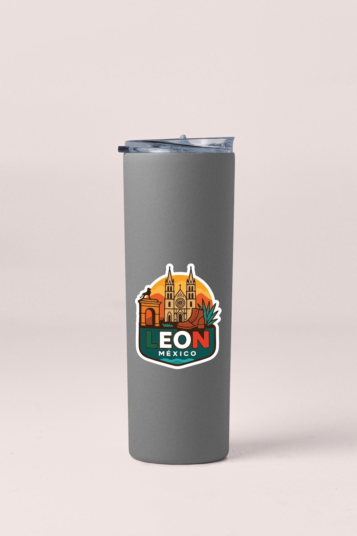 A gray insulated tumbler with a sticker featuring the iconic landmarks of Leon, Mexico.