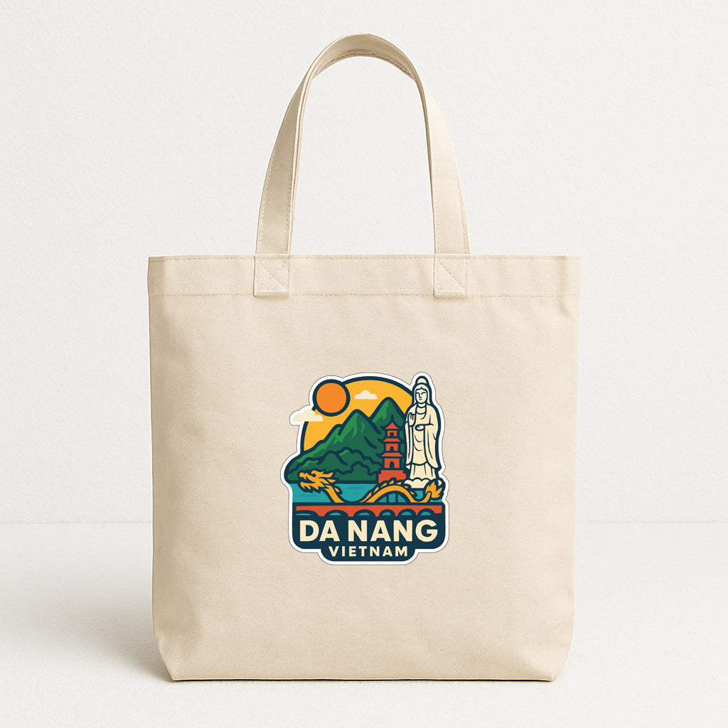 A beige tote bag with a printed design featuring a temple, mountains, and a sun, along with the text "DA NANG VIETNAM".