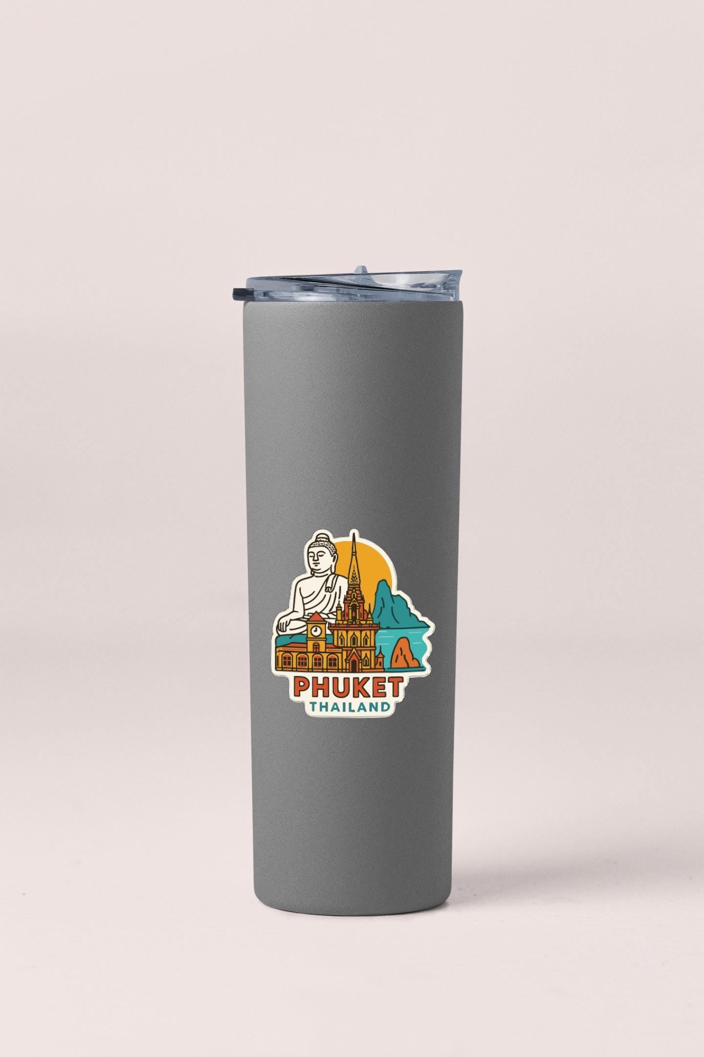 A gray insulated tumbler with a sticker depicting a temple and Buddha figure, along with the text "PHUKET THAILAND".