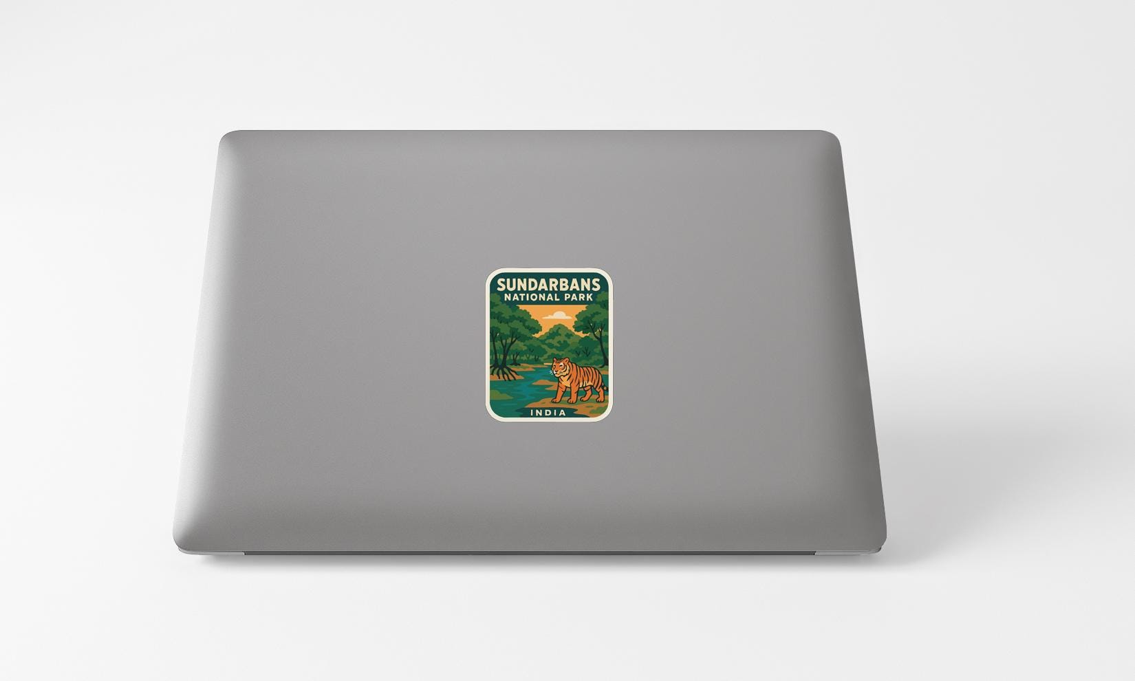 A sticker on the back of a laptop, depicting a tiger in a natural setting.