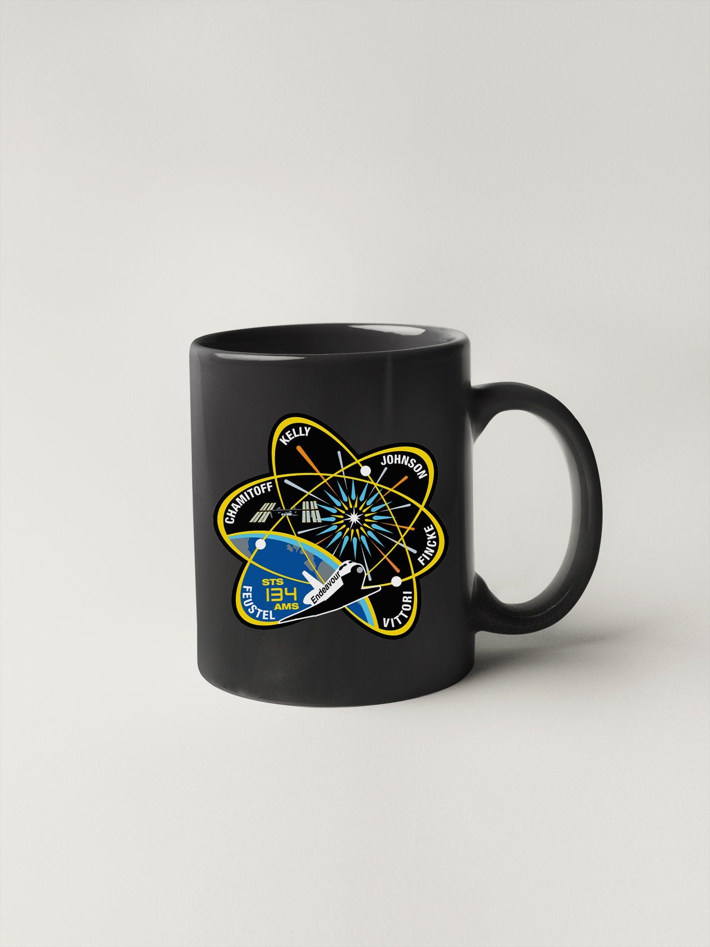 a black coffee mug with an image of a space shuttle on it