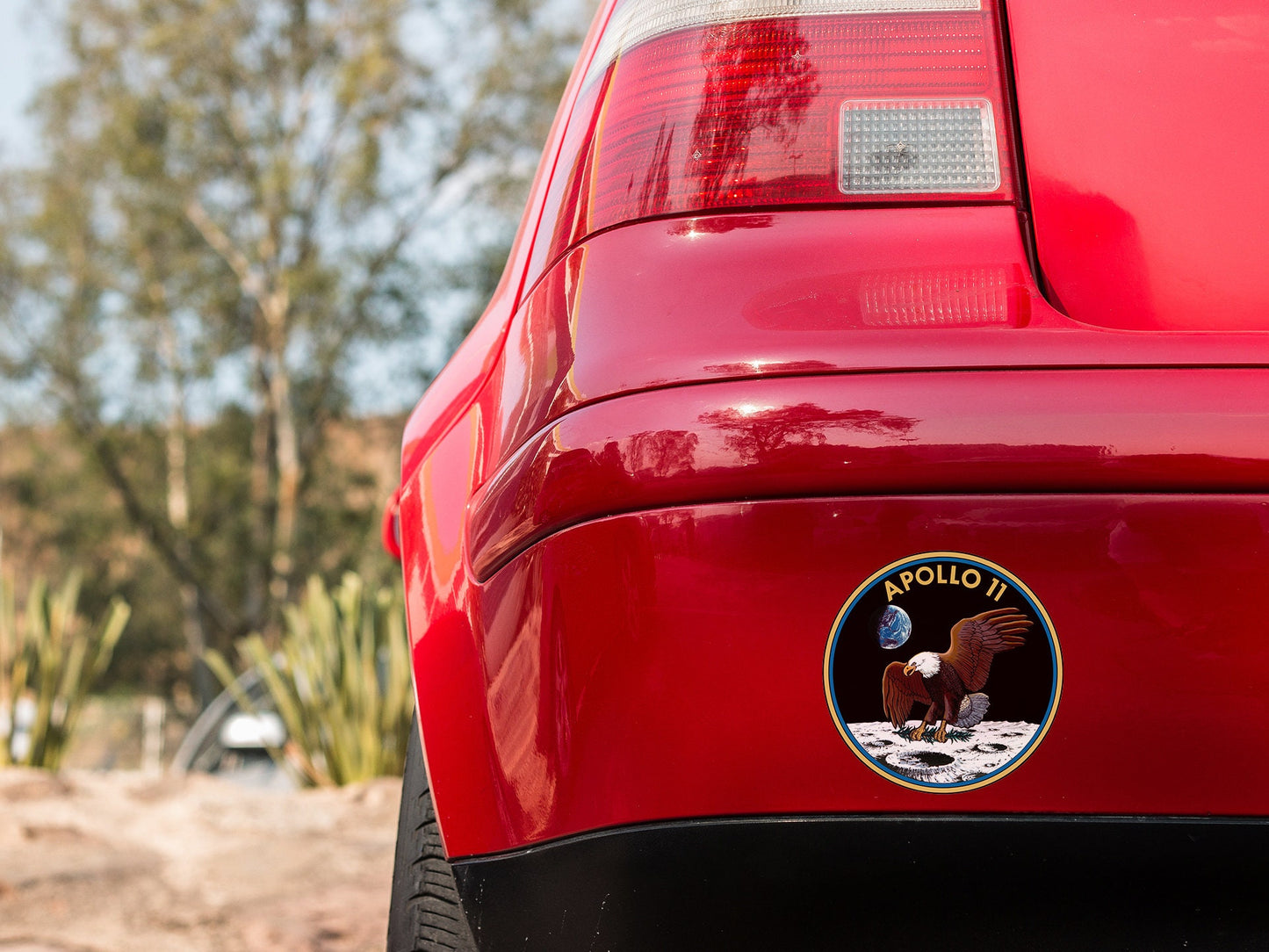 a close up of a red car with a horse sticker on it