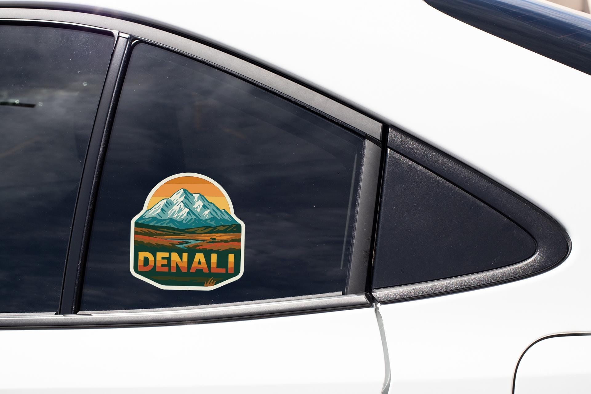 A sticker on the side of a car window that says "DENALI".