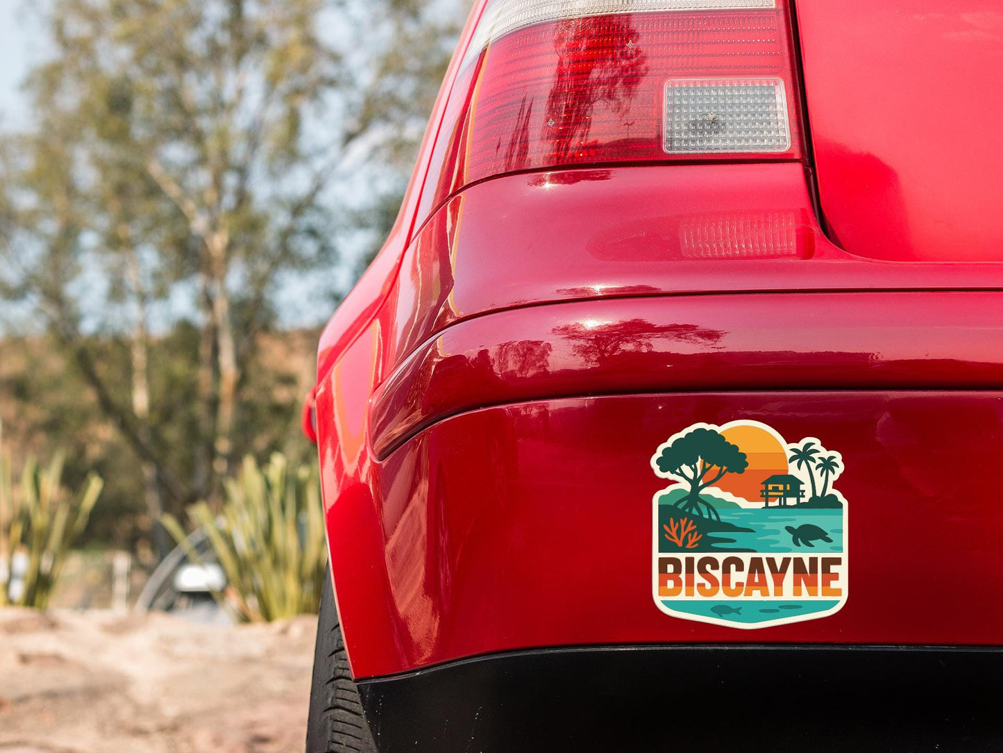the rear end of a red car with a sticker on the trunk that says "BISCAYNE".