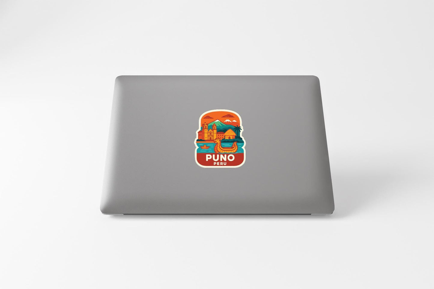 a sticker with an illustration of a mountain and the text "PUNO PERU" on a laptop.
