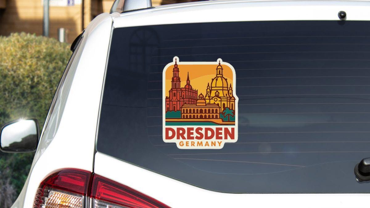 A sticker on the rear window of a car that features the Dresden, Germany skyline.