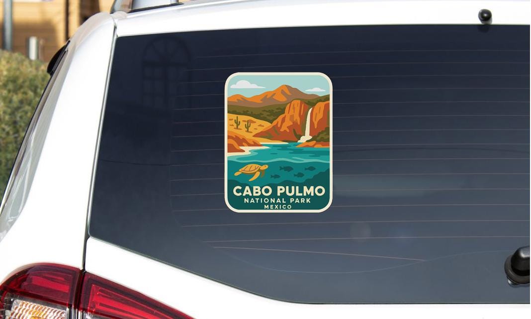 a sticker on the rear window of a vehicle, depicting a scenic landscape with mountains, a waterfall, and a turtle.