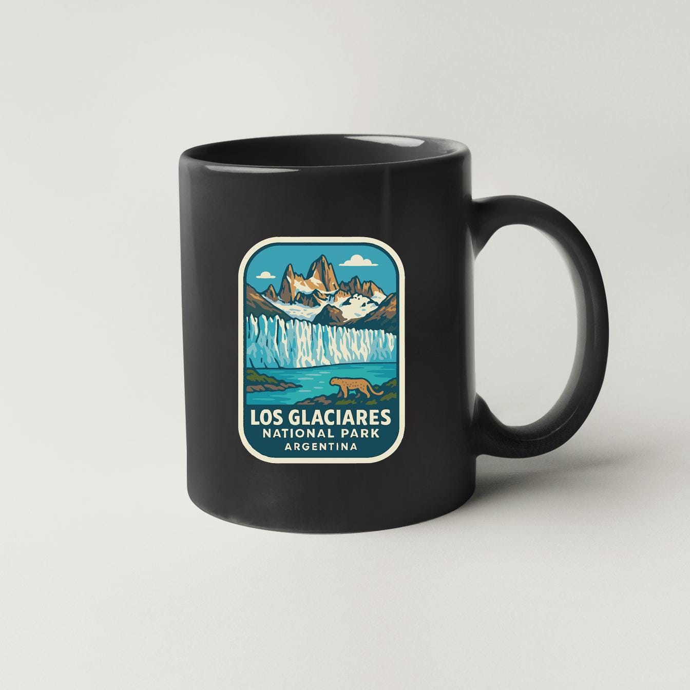A black coffee mug with a graphic design depicting the Los Glacios National Park in Argentina.