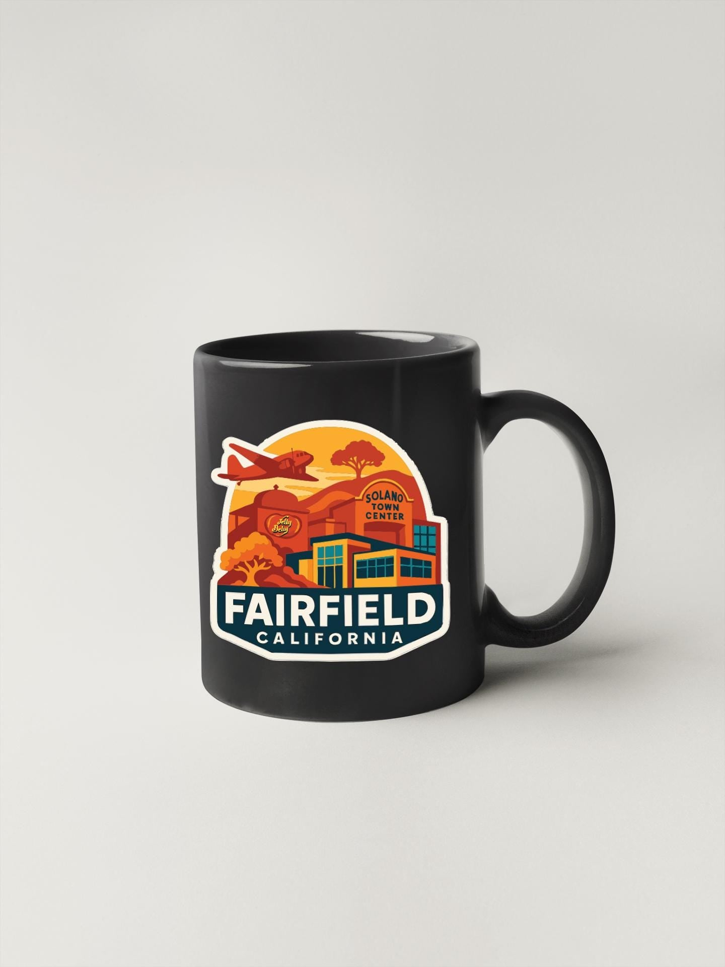 A black coffee mug with a colorful graphic design depicting a cityscape and the text "FAIRFIELD CALIFORNIA".