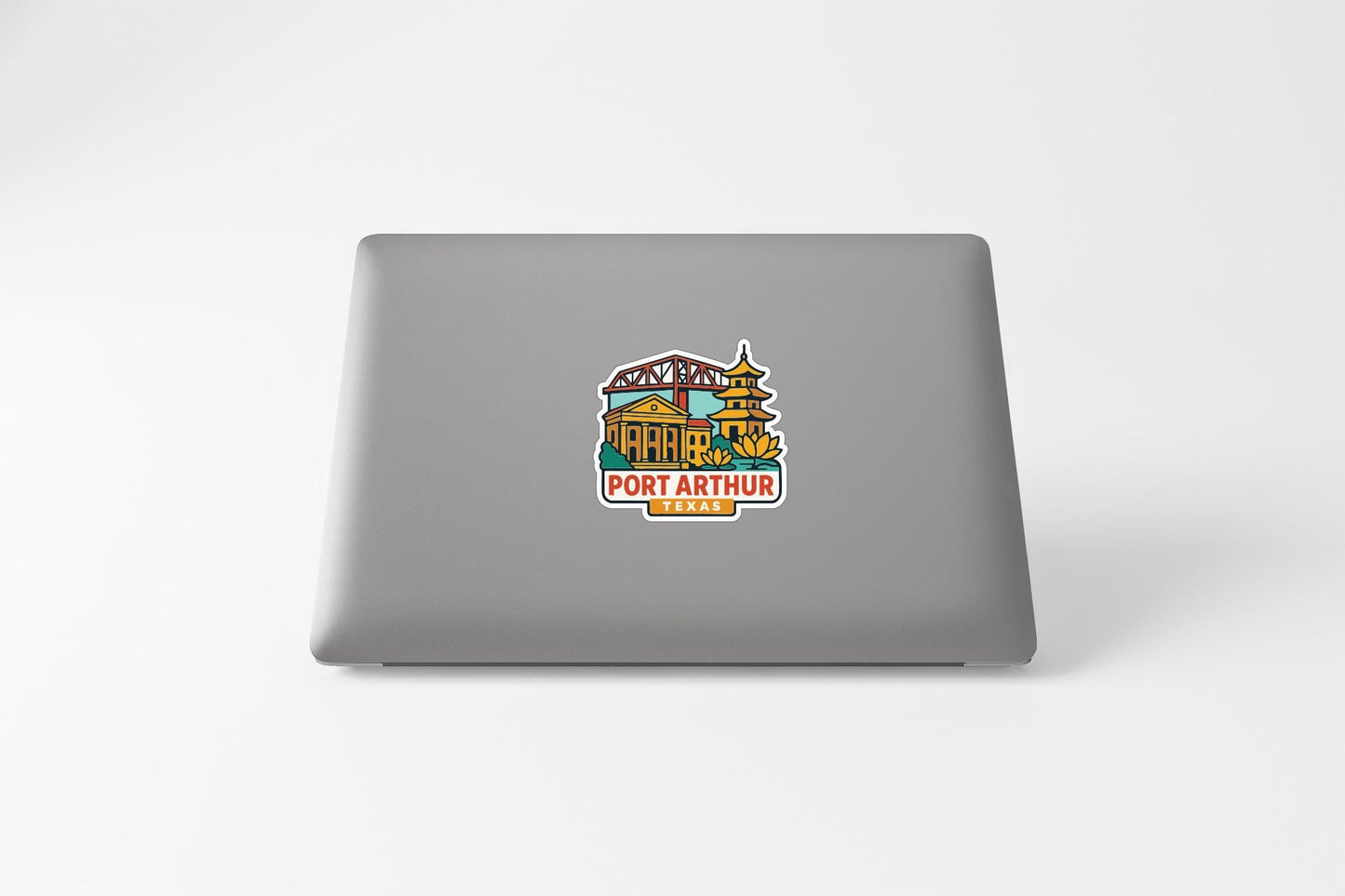 A sticker on the back of a laptop, featuring an illustration of a building and the text "PORT ARTHUR TEXAS".