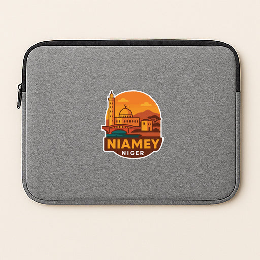 A gray laptop sleeve with a sticker depicting a city skyline and the text "NIAMEY NIGER".