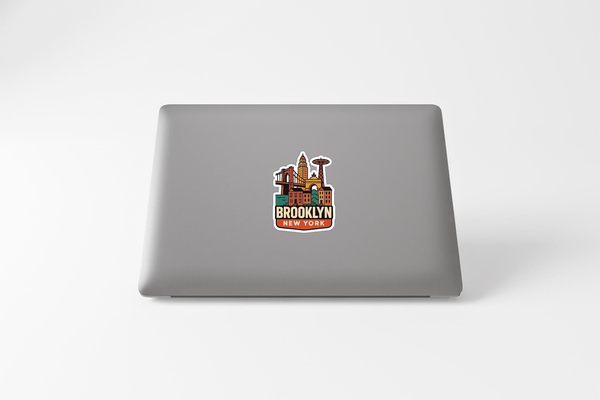 A sticker on the back of a laptop, featuring an illustration of a city skyline with the text "BROOKLYN WEST YORK" prominently displayed.