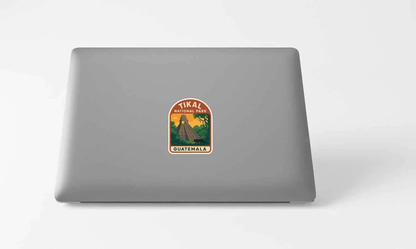 A sticker on the back of a laptop, depicting a tropical landscape with a person standing in the center.