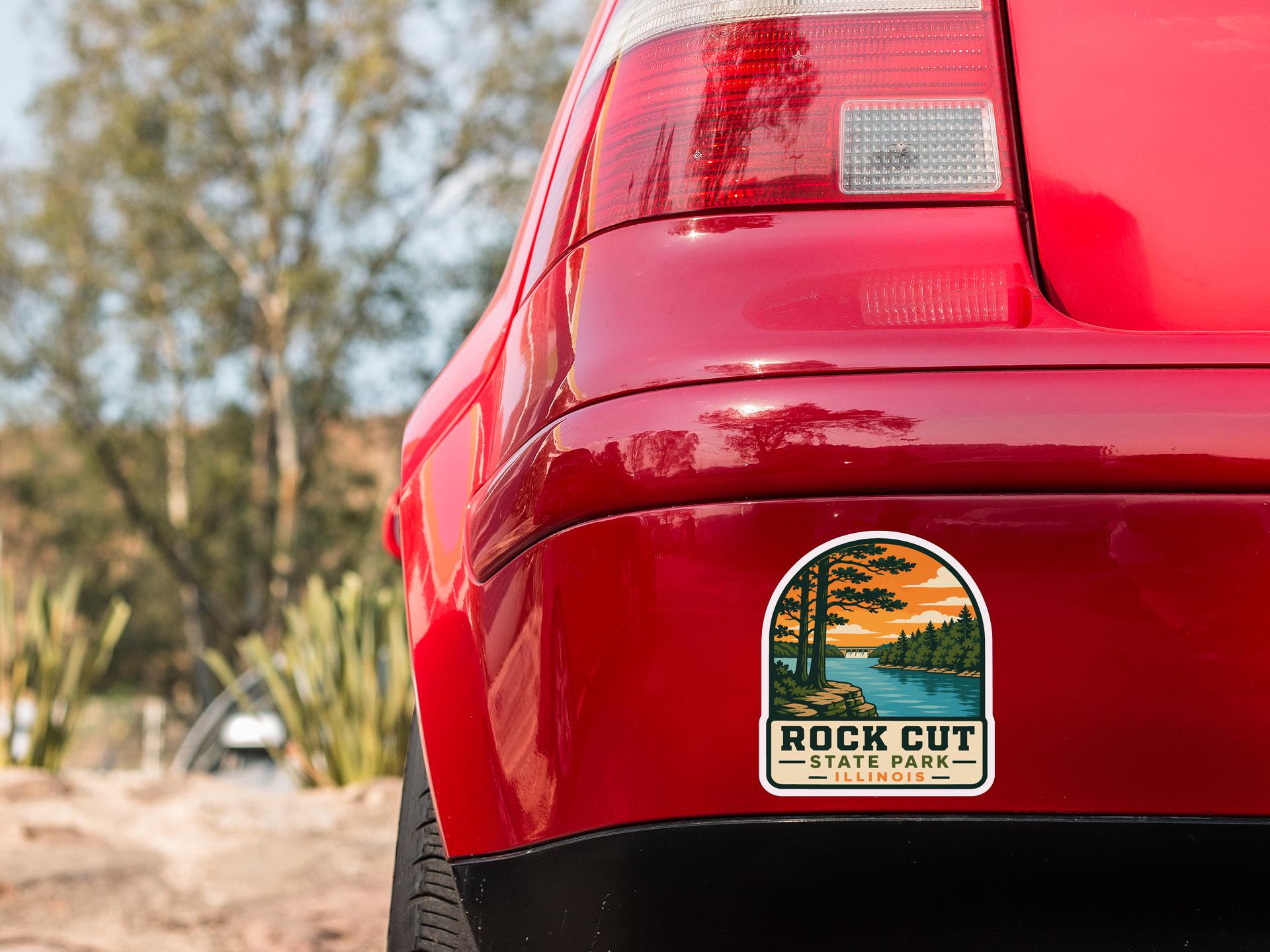 the rear end of a red car with a sticker on the back window that says "Rock Cut State Park - Illinois".
