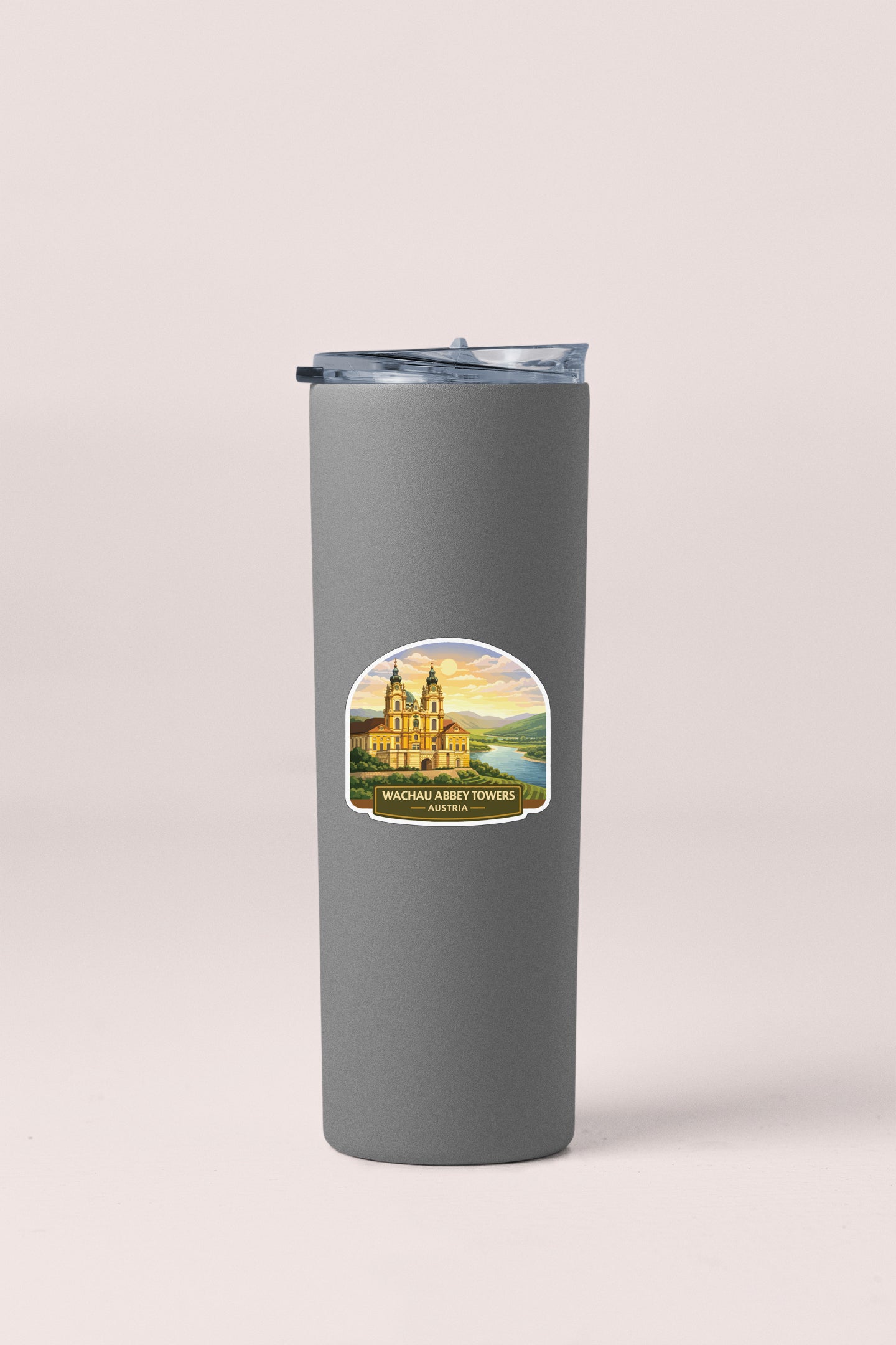 A gray insulated tumbler with a sticker depicting a castle and towers.