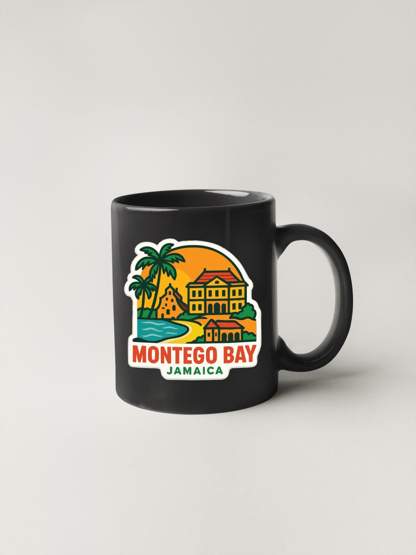 A black coffee mug with a colorful illustration of Montego Bay, Jamaica, featuring a palm tree, a building, and a sunset.