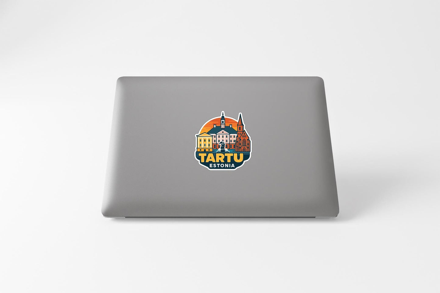 a sticker with a graphic of a building and the text "TARTU ESTONIA" on a grey laptop.