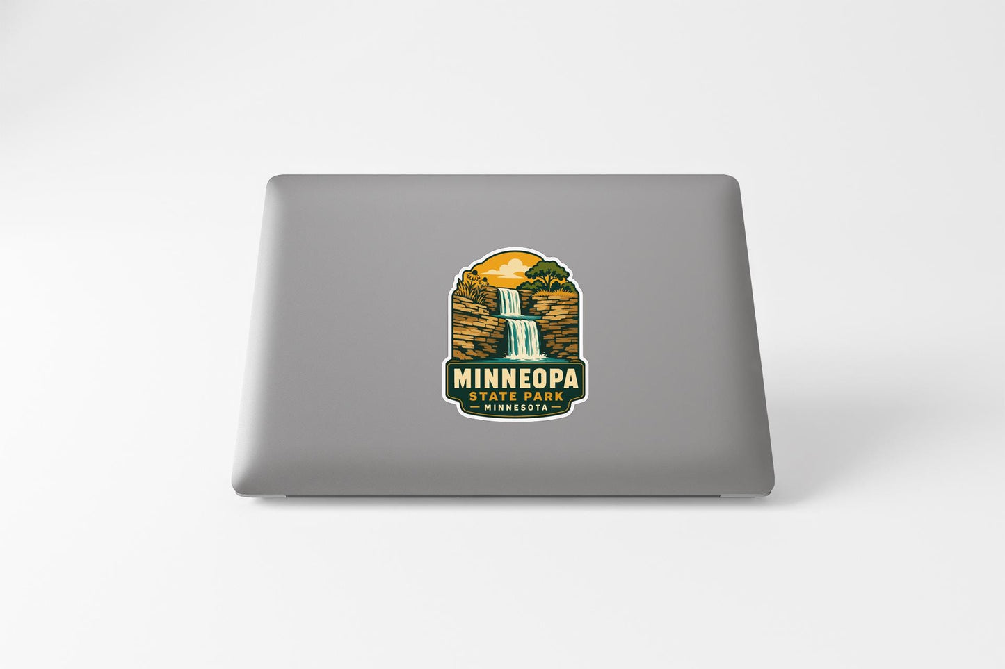 A sticker on the back of a laptop, depicting a waterfall and the text "MINNEAPARK, MINNESOTA".