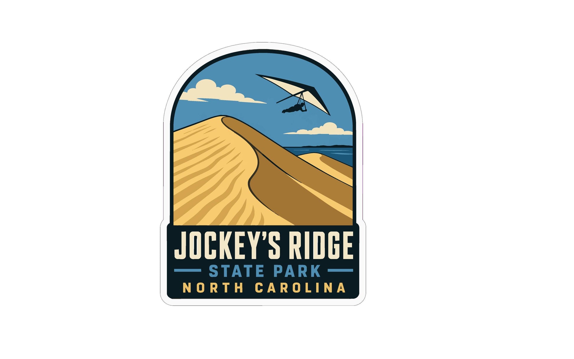 A sticker or label featuring a mountain landscape with a person flying a parasail in the sky, along with the text "Jockey's Ridge State Park North Carolina".