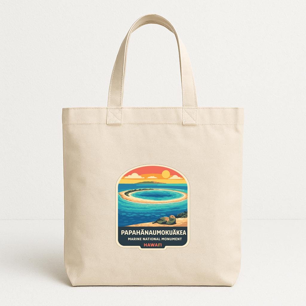 A beige tote bag with a printed design depicting a tropical island scene, including a circular island, palm trees, and a sunset.